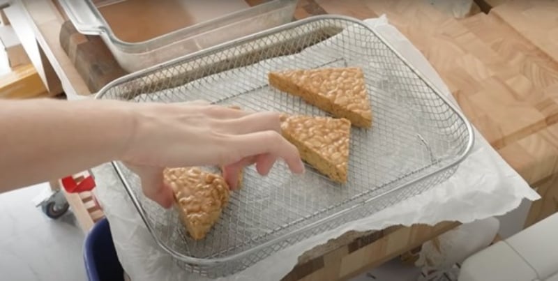 Merle O'Neal places four marinated tempeh wedges on a baking sheet for oven drying