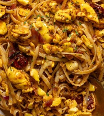 a bowl of ackee pasta with jerk marinade and tomato