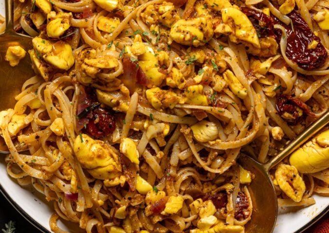 a bowl of ackee pasta with jerk marinade and tomato