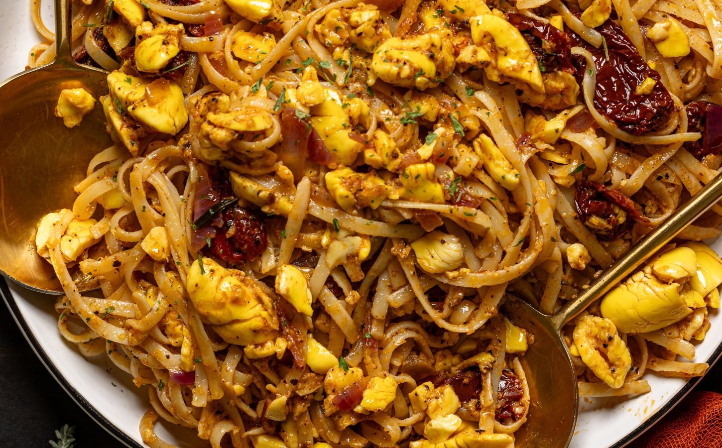 a bowl of ackee pasta with jerk marinade and tomato