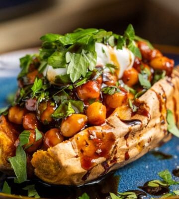 buffalo chickpeas on roasted sweet potato topped with coriander and coconut yogurt for vegan dinners where chickpeas are the start of the show