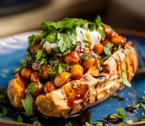buffalo chickpeas on roasted sweet potato topped with coriander and coconut yogurt for vegan dinners where chickpeas are the start of the show