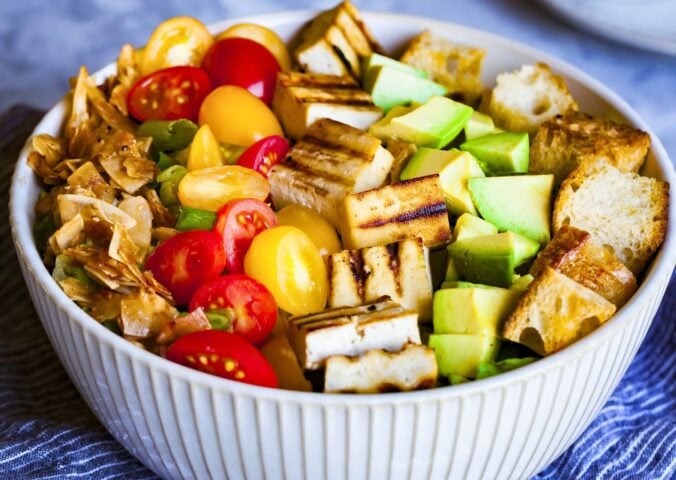 a bowl of California cobb salad with smoky coconut bacon