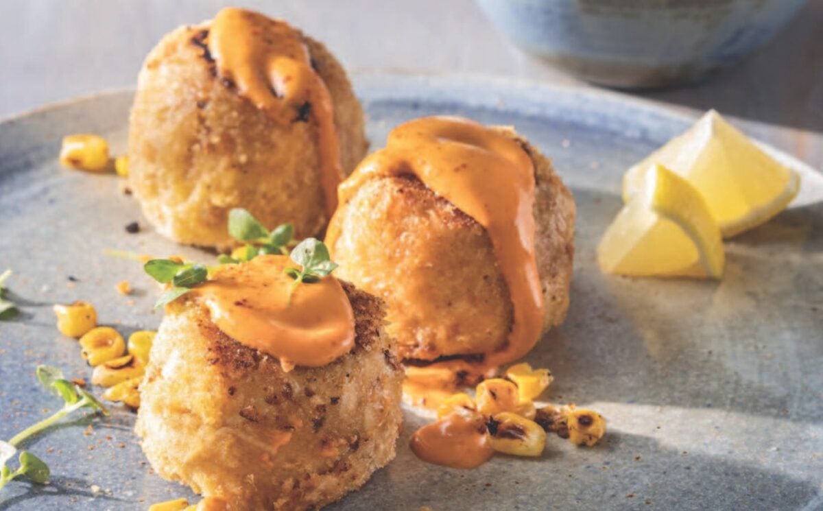 a picture of three small vegan crab cakes with spicy mayo and lemon wedges for vegan starter ideas for your next dinner party