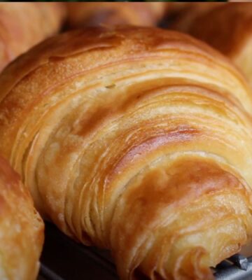 A close-up of some homemade vegan croissants on a baking tray
