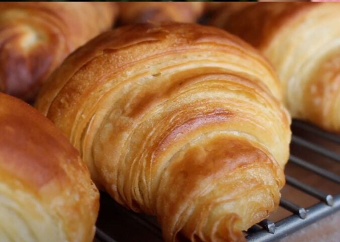A close-up of some homemade vegan croissants on a baking tray