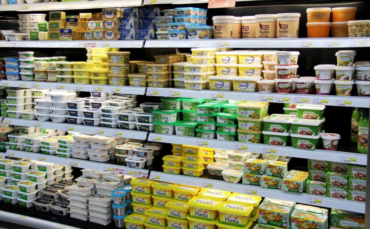 Photo shows the refrigerated dairy section in a supermarket, including a variety of different butter, margarine, and spread products