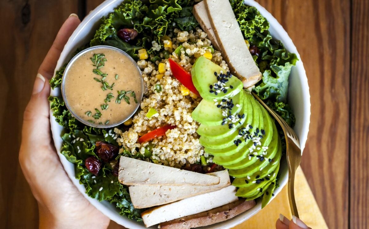 a bowl of kale salad with quinoa pilaf and creamy balsamic dressing