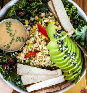 a bowl of kale salad with quinoa pilaf and creamy balsamic dressing