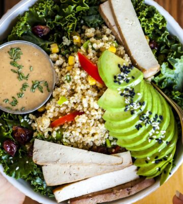 a bowl of kale salad with quinoa pilaf and creamy balsamic dressing