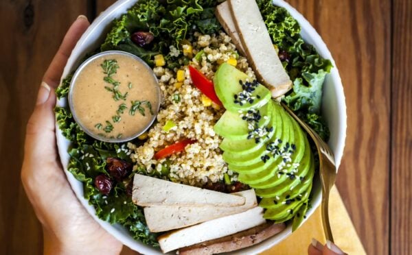 a bowl of kale salad with quinoa pilaf and creamy balsamic dressing