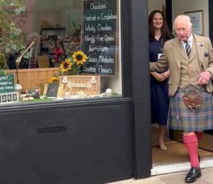 Photo shows King Charles and Fetcha Chocolates founder Fiona McArthur in the doorway of the shop