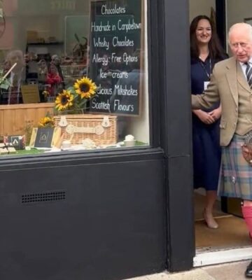 Photo shows King Charles and Fetcha Chocolates founder Fiona McArthur in the doorway of the shop