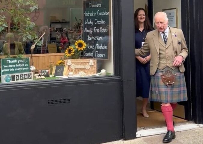 Photo shows King Charles and Fetcha Chocolates founder Fiona McArthur in the doorway of the shop