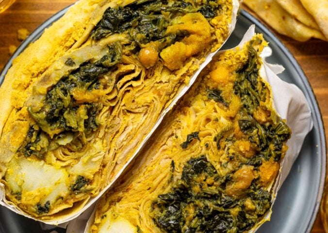a loaded dhal puri roti with chana, aloo, and spinach