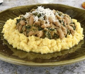 polenta topped with cannellini bean stew with kale and nutritional yeast