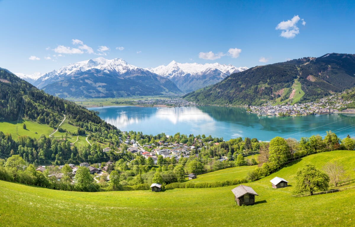 Photo shows a green valley and blue lake amid mountains