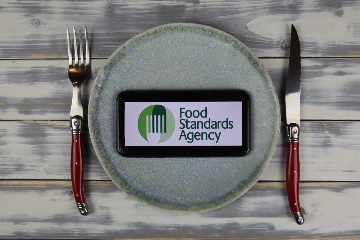 Photo shows a plate flanked by knife and fork with a phone on it, bearing the UK's Food Standards Agency (FSA) logo
