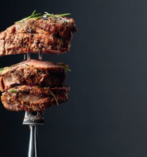 Photo shows a silver fork with several thick pieces of steak on it