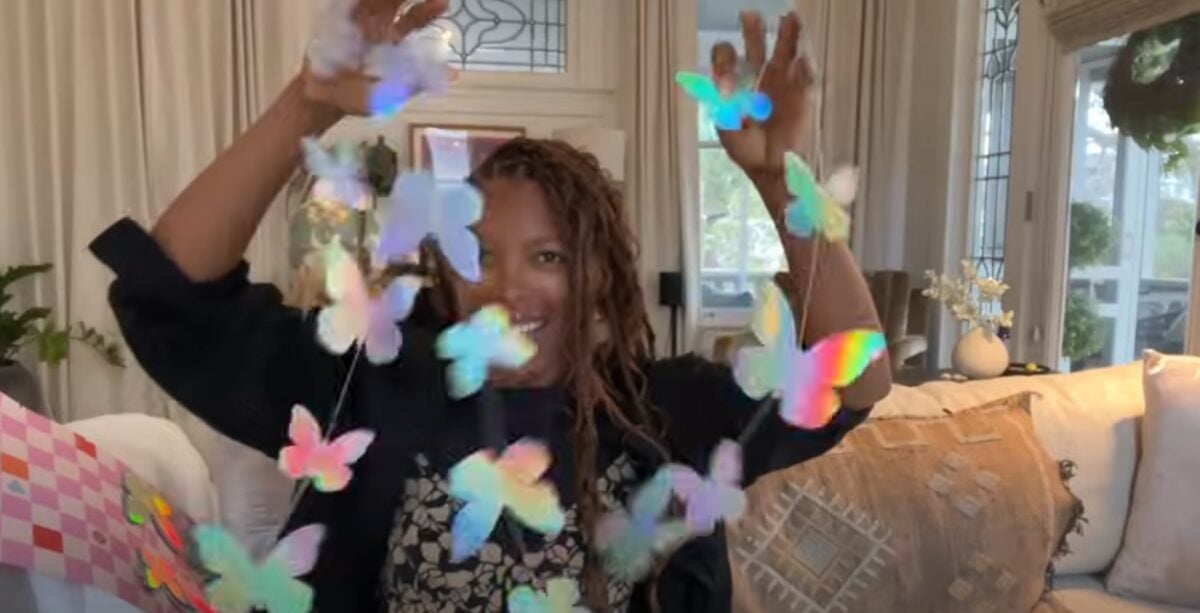 Jenné Claiborne holding up butterfly decorations for her vegan kids birthday party