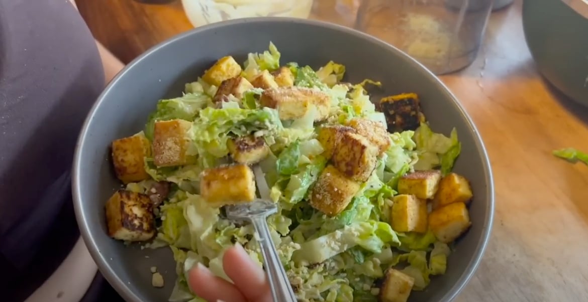 A vegan caesar salad with cashew parm and tofu
