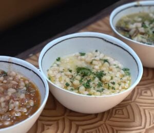 With these tomato and herb, lemon and miso, and leek and mushroom beans, viewed here in white and blue bowls on a wooden table, Miyoko Schinner is making beans sexy again