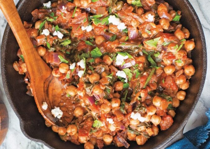 a bowl of Mediterranean chickpea spinach stew with onion, garlic, and balsamic
