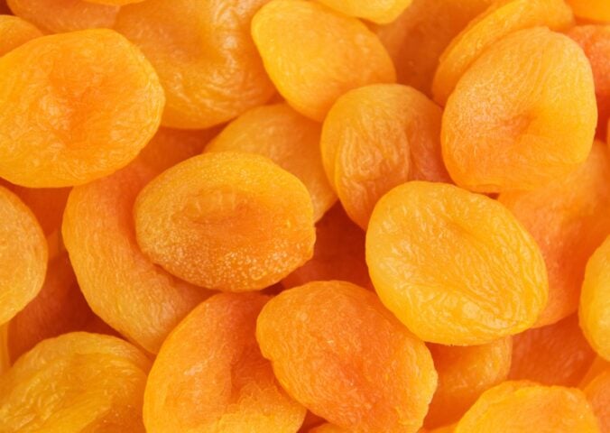 A close-up shot of bright orange dried apricots