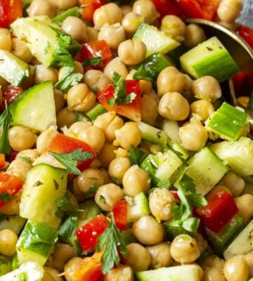 a herby chickpea salad with bell pepper, cucumber, garlic, lemon, and olive oil