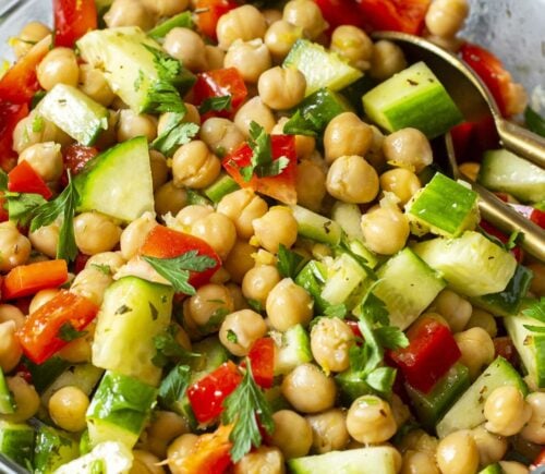 a herby chickpea salad with bell pepper, cucumber, garlic, lemon, and olive oil