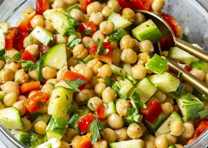 a herby chickpea salad with bell pepper, cucumber, garlic, lemon, and olive oil