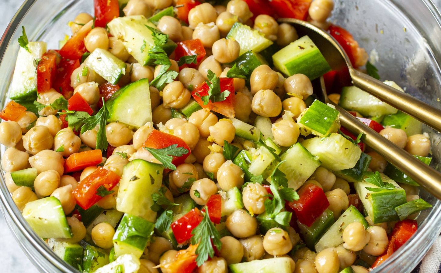 a herby chickpea salad with bell pepper, cucumber, garlic, lemon, and olive oil