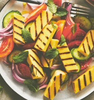 golden grilled malloumi, a vegan take on halloumi on a plate with salad
