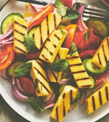 golden grilled malloumi, a vegan take on halloumi on a plate with salad