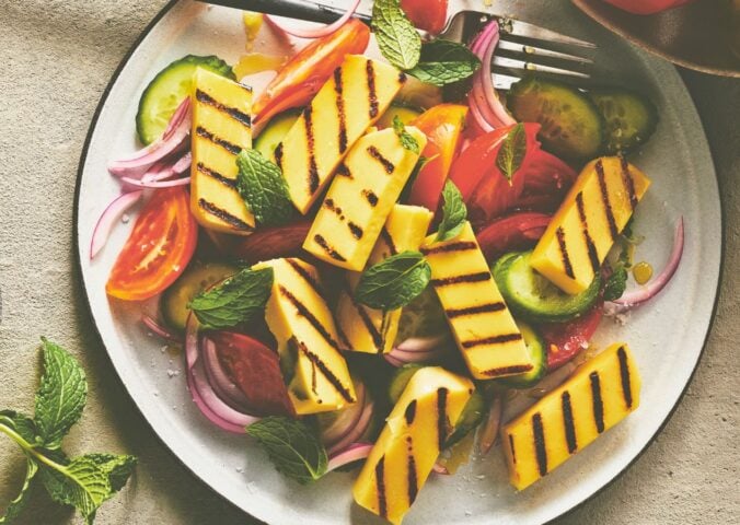 golden grilled malloumi, a vegan take on halloumi on a plate with salad