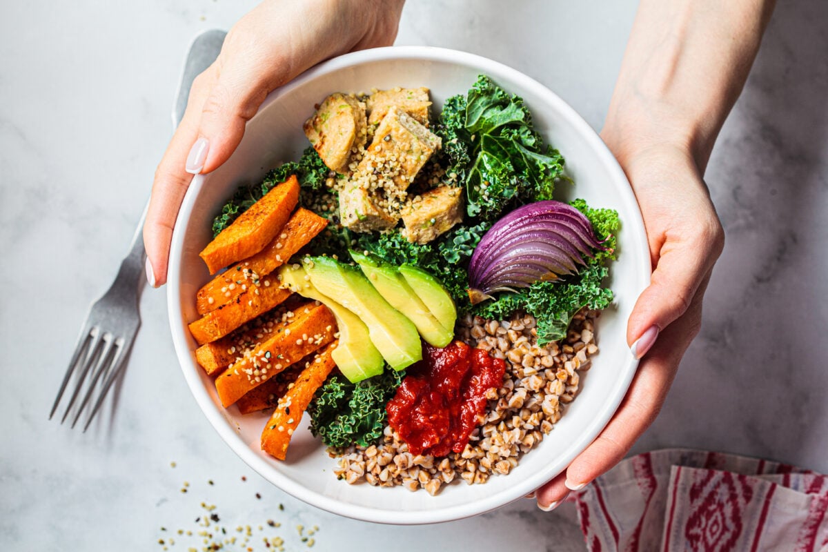 A woman holding a vegan buddha bowl