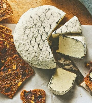 A wheel of snow white rind vegan cheese like brie or camembert