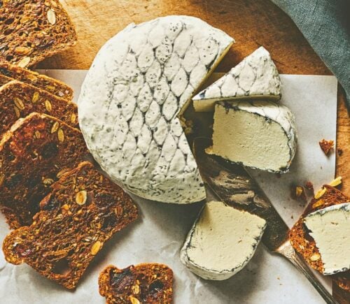A wheel of snow white rind vegan cheese like brie or camembert