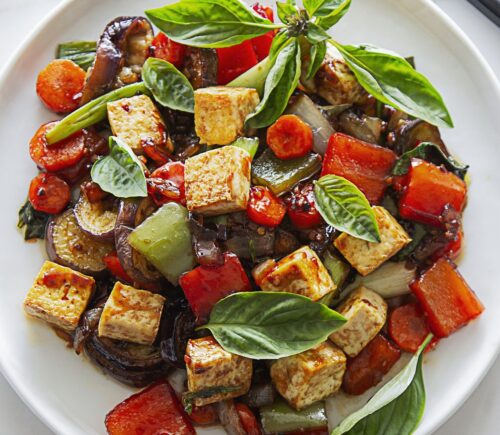 vegan spicy eggplant with tofu, chinese aubergine, peppers, and Thai basil