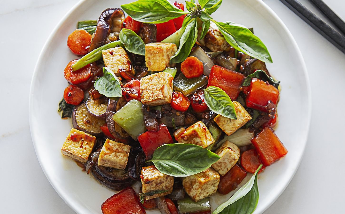 vegan spicy eggplant with tofu, chinese aubergine, peppers, and Thai basil