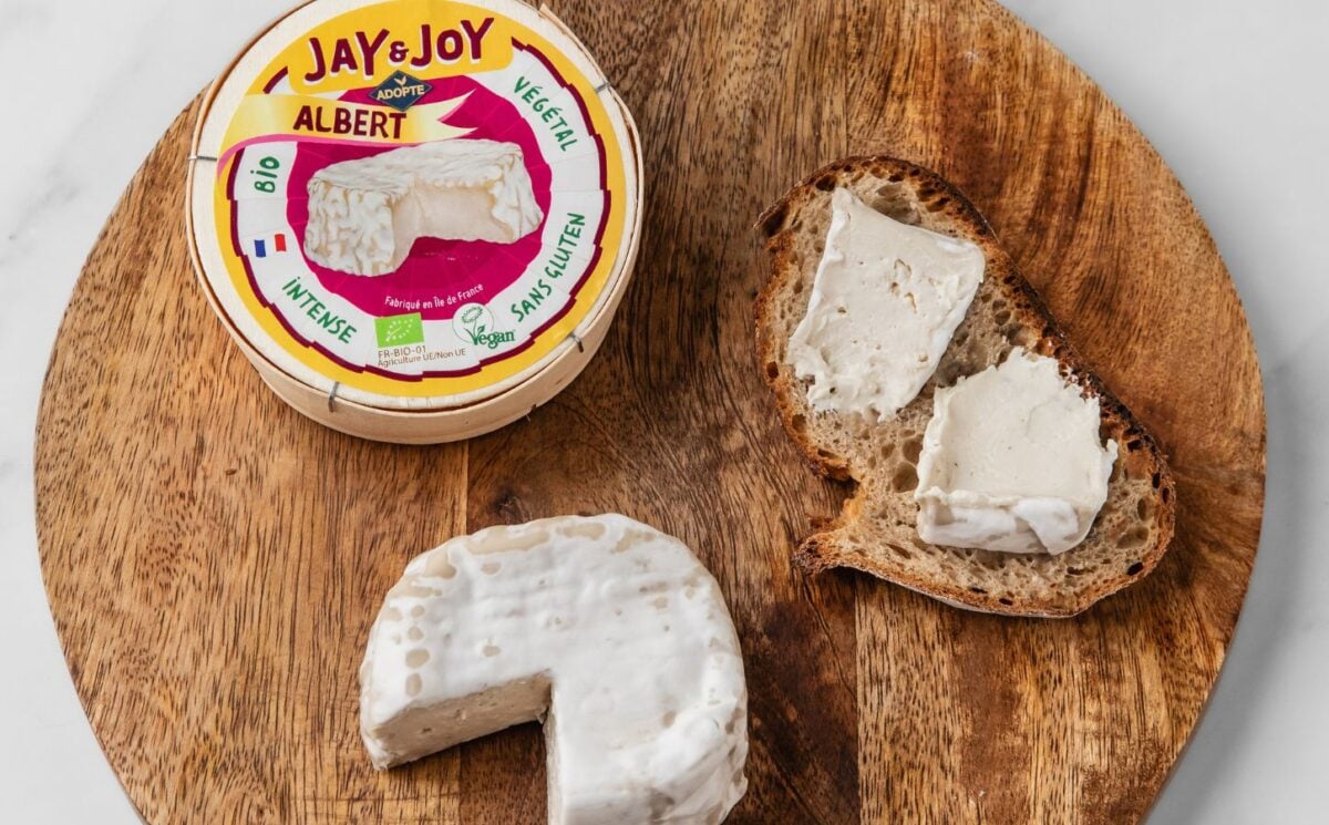 Photo shows a wheel of "Albert," the vegan camembert from Jay & Joy, alongside the packaging and some spread on bread