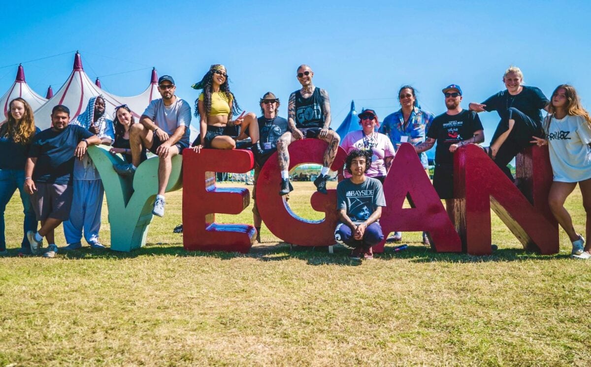 Vegan Camp Out attendees at the festival posting against some large letters reading "Vegan"