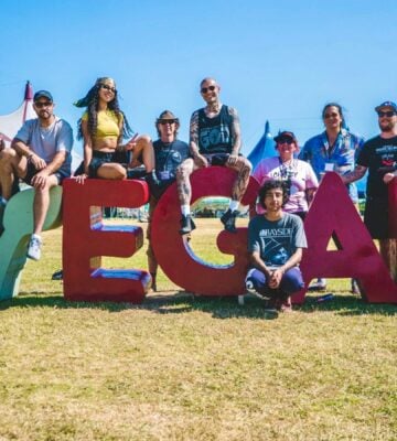 Vegan Camp Out attendees at the festival posting against some large letters reading "Vegan"