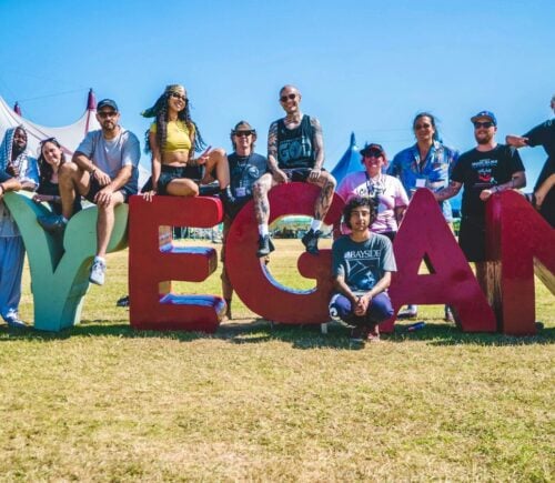 Vegan Camp Out attendees at the festival posting against some large letters reading "Vegan"
