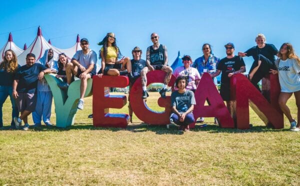 Vegan Camp Out attendees at the festival posting against some large letters reading "Vegan"