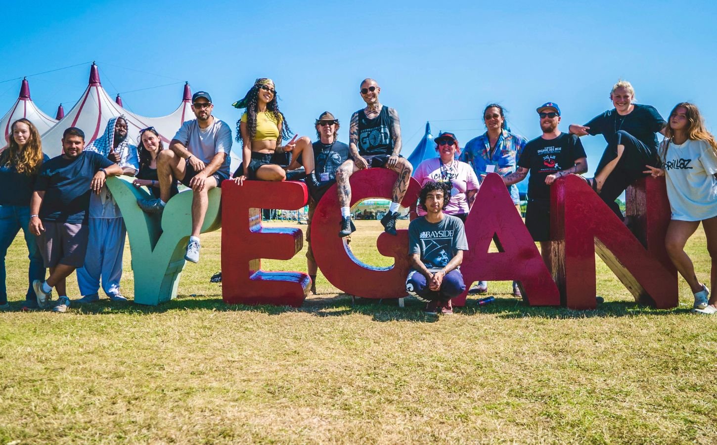 Vegan Camp Out attendees at the festival posting against some large letters reading "Vegan"