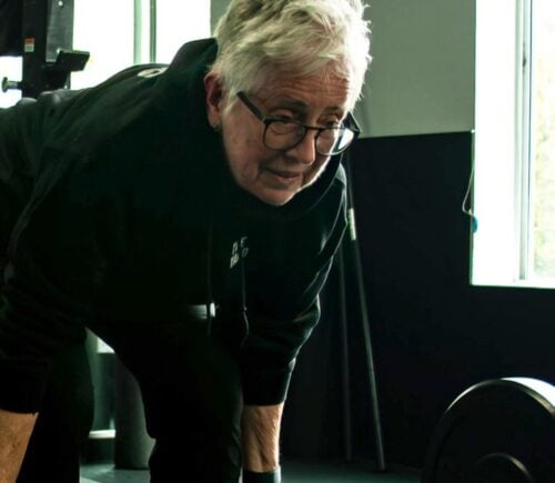 Photo shows Sister Pat Farrell, a vegan nun and 72 year old powerlifter, deadlifting a barbell