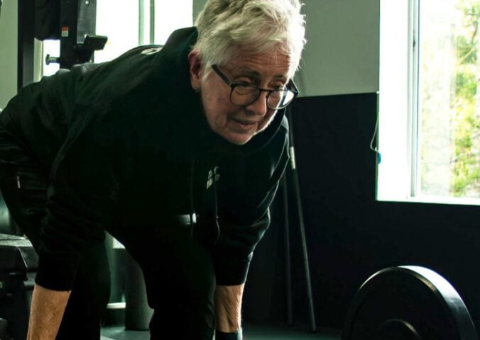 Photo shows Sister Pat Farrell, a vegan nun and 72 year old powerlifter, deadlifting a barbell