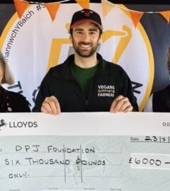 Photo shows people from Vegans Support the Farmers and the DPJ Foundation holding a cheque for the final amount at the Royal Welsh Show