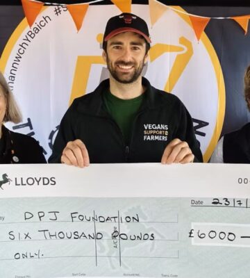 Photo shows people from Vegans Support the Farmers and the DPJ Foundation holding a cheque for the final amount at the Royal Welsh Show